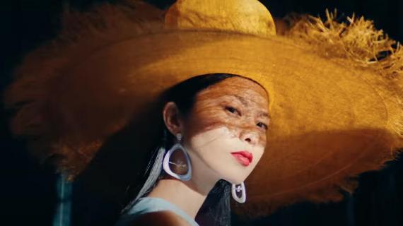 A woman wearing a straw hat and airplane themed earrings